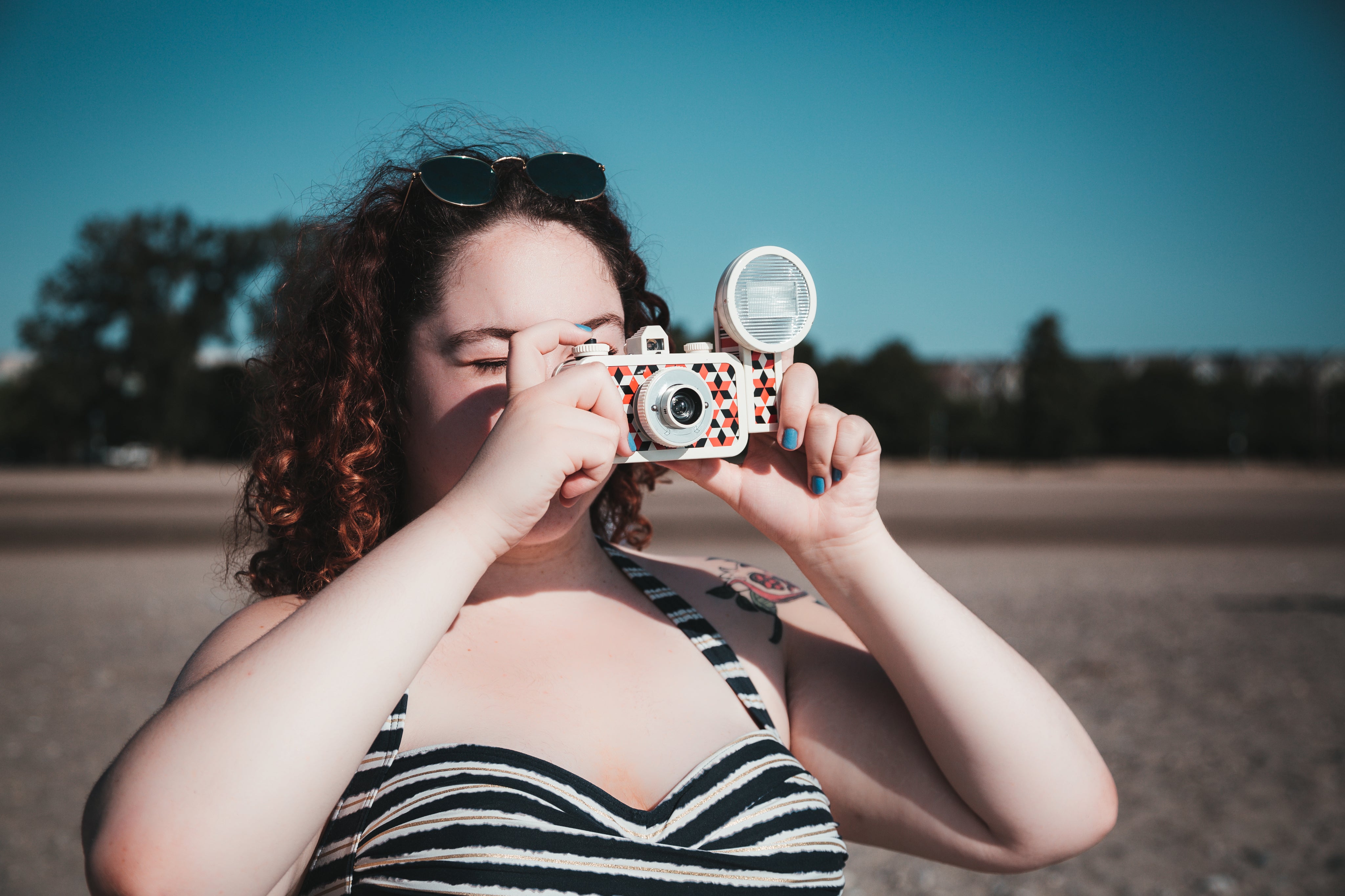 files/young-woman-in-sunglasses-taking-photograph-on-beach.jpg
